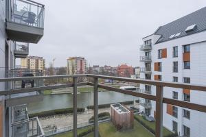 グダニスクにあるApartament z widokiem na rzekę Gdańsk Stare Miastoの建物のバルコニーから川の景色を望めます。