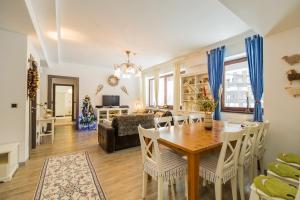 a dining room and living room with a table and chairs at Charming 3-Bedroom Apartment in Poiana Brasov