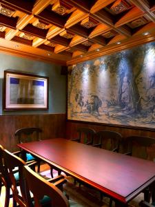 una mesa en una habitación con una gran pintura en la pared en Casa Rural La Parra de Maribel, en Alquézar
