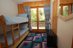 Zimmer mit 2 Etagenbetten und einem Fenster in der Unterkunft La Foret Apartment With Spectacular Mountain Views in Nendaz