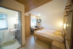 a bedroom with a bed and a bathroom with a sink at Gasthof Staud'nwirt in Bad Aussee