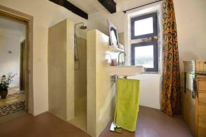 ein Bad mit einem Waschbecken und einem Fenster in der Unterkunft B&B Champdelaplume in Barjac