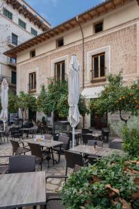 a patio with tables and umbrellas in front of a building at Soller Plaza in Sóller