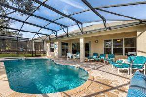 a swimming pool with a glass roof on a patio at Olivia's Dream Villa on WindsorHills in Orlando
