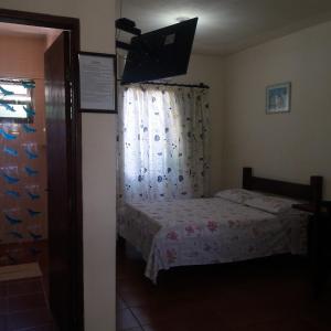a small bedroom with a bed and a window at Chalés Xibayka Ilhabela in Ilhabela