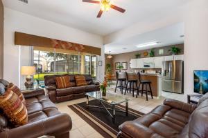 a living room with leather couches and a kitchen at Olivia's Dream Villa on WindsorHills in Orlando