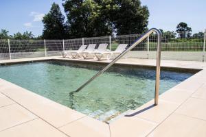 a swimming pool with chairs and a metal hand rail at Can LLorens in Llagostera