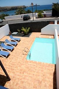 a swimming pool with lounge chairs next to a house at Casa Coloradas in Playa Blanca