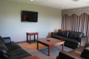 a living room with couches and a tv and a table at Glendenning Hall at Holland College in Charlottetown