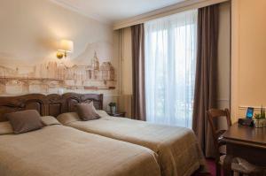 a hotel room with two beds and a window at Familia Hotel in Paris