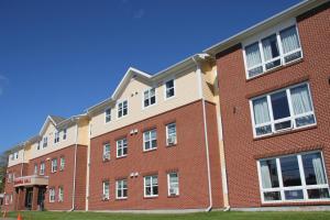 - un grand bâtiment en briques rouges avec des fenêtres blanches dans l'établissement Glendenning Hall at Holland College, à Charlottetown