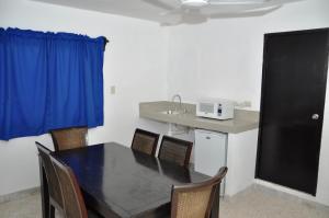 a dining room table with chairs and a microwave at Posada del Parque in Mazatlán