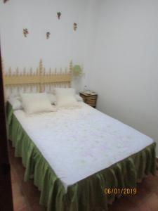 a bedroom with a large bed with white sheets at CALLE CALVARIO 10 in Zufre