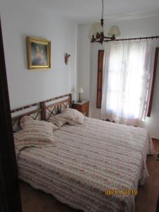 1 dormitorio con cama y ventana en CALLE CALVARIO 10, en Zufre