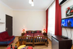 ein Wohnzimmer mit 2 Betten und einem Flachbild-TV in der Unterkunft Gis Guest House in Tbilisi City