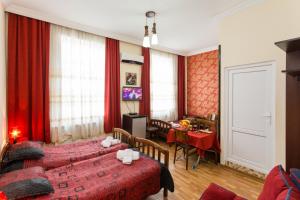sypialnia z czerwonymi zasłonami i jadalnia ze stołem w obiekcie Gis Guest House w mieście Tbilisi City