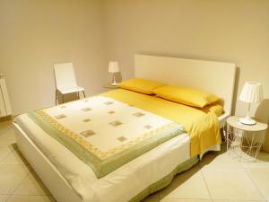 1 dormitorio con 1 cama grande con almohadas amarillas en Villa Feluchia Tra Il Mare E Il Vulcano, en Acireale