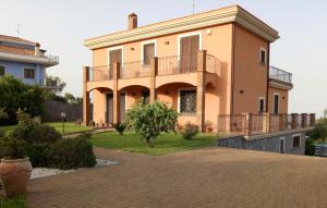 uma casa grande com uma varanda e uma entrada em Villa Feluchia Tra Il Mare E Il Vulcano em Acireale