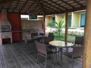Imbassai Summer Flats Village في ايمباسّاي: فناء به طاولات وكراسي وشواية