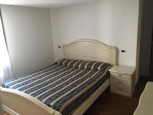 a bed in a small room with a night stand at Appartamenti Ghetto Vecio in Venice