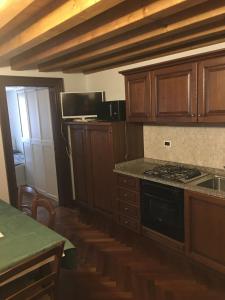 a kitchen with wooden cabinets and a stove top oven at Appartamenti Ghetto Vecio in Venice