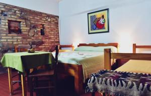 - une chambre avec 2 lits, une table, une table et des chaises dans l'établissement Hostel Ctalamochita, à Embalse