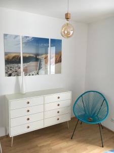 a white dresser and a blue chair in a room at Cosy Splendor / City Center in Graz