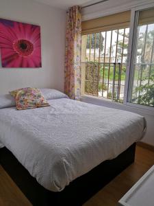 a bedroom with a bed with a pink flower on the wall at Villa con piscina privada in Torremolinos +43 photos