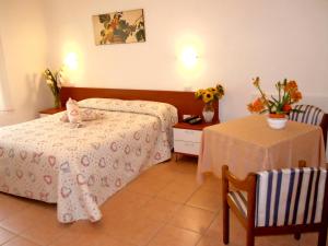 a hotel room with a bed and a table with a table at Albergo Elvira in Tabiano