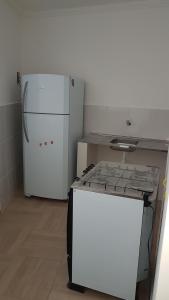 a kitchen with a white refrigerator and a stove at APARTAMENTO DO OTTO in Oliveira Fortes