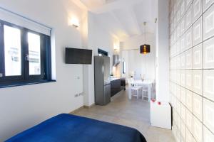 a white room with a blue bed and a kitchen at Valentia Apartments - Mercado Central in Valencia