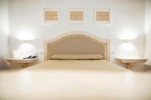 a white bedroom with a bed and two night stands at La Magione in Foggia