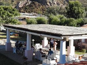 people are gathered around a picnic table at Hotel Eros in Vulcano