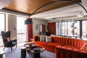 a living room with orange furniture and windows at Bobby Hotel in Nashville
