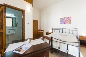 a bedroom with a bed and a table and a bathroom at Masseria Valente in Ostuni