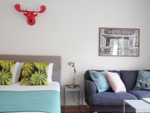 una camera da letto con un letto e un divano di Ripple - Modern Condo with pool, aircon, parking a Lisbona