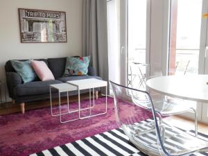 un soggiorno con un divano e un tavolo di Ripple - Modern Condo with pool, aircon, parking a Lisbona