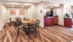 a dining room with a table and chairs and a kitchen at Cobblestone Inn & Suites - Durand in Durand