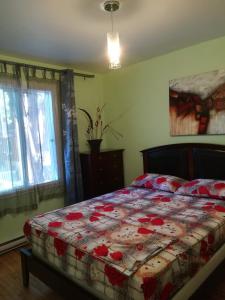 um quarto com uma cama com um edredão vermelho e branco em Montreal Authentic appartment em Montréal