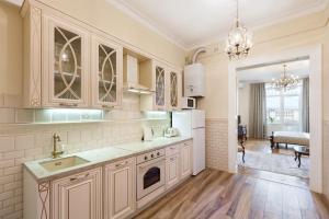 a kitchen with white cabinets and a sink at LUXOVSKI apartment in Lviv