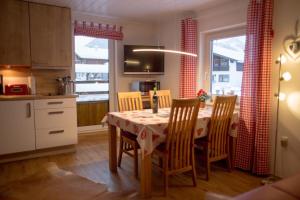 a kitchen with a dining room table with chairs and a kitchen at Almsternchen 2 - Almsternchen 3 in Oberstdorf