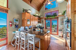 a kitchen with a large island with white bar stools at Art on the Beach in Stuart