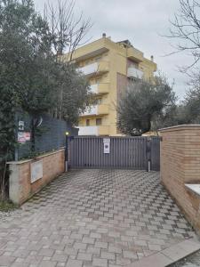 a driveway with a fence and a building in the background at Colle dell'Ara in Chieti