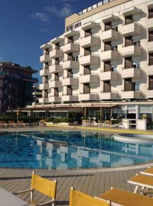 um hotel com piscina em frente a um edifício em Hotel David em Cesenatico