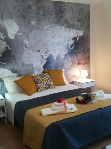 two beds in a room with a map on the wall at L' Attico di Kely in Santa Elisabetta