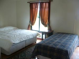 a bedroom with a bed and a window at Cabañas Krava Inn in Hanga Roa