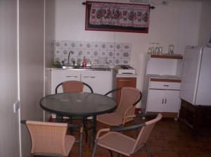 a kitchen with a table and chairs and a refrigerator at Cabañas Krava Inn in Hanga Roa