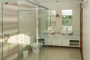 a bathroom with two sinks and a glass shower at Marruá Hotel in Bonito