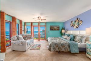 a bedroom with a bed and a couch and a chair at Art on the Beach in Stuart +75 photos