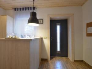 a kitchen with a counter and a black door at Willa Plażowa in Mielenko